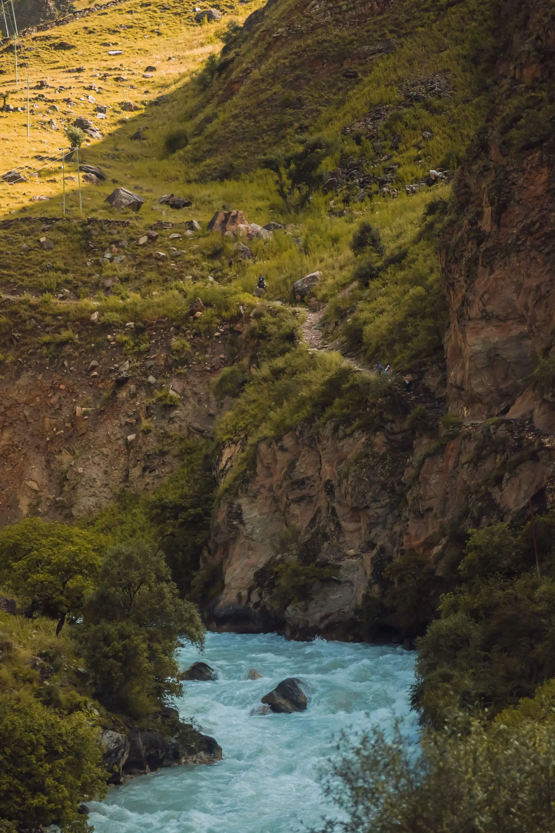 A turquoise river flowing between rocky hills in Nepal.